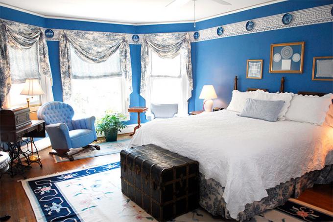 अंतरिक्ष को कम करने के लिए नीली दीवारों के साथ एक बेडरूम की तस्वीर