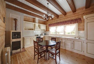 लकड़ी के फर्श और बीम वाली छत के साथ प्रोवेंस शैली की रसोई।